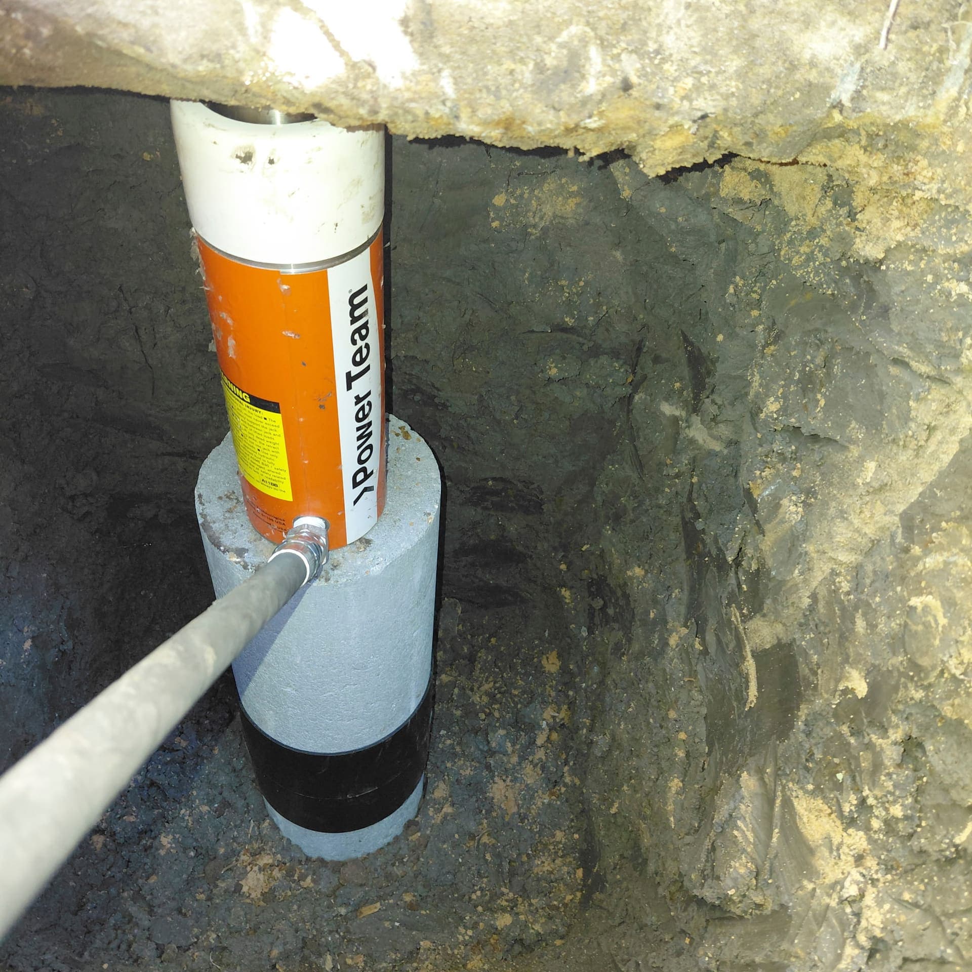 Close-up of concrete cylinders and the ramming machine inside the excavation