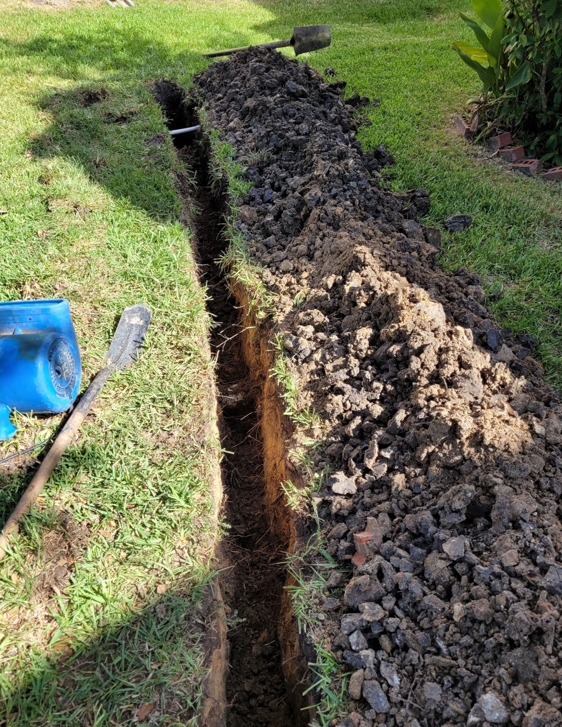 Empty excavated trench with a blue fan at left, prepared for BioBarrier® installation