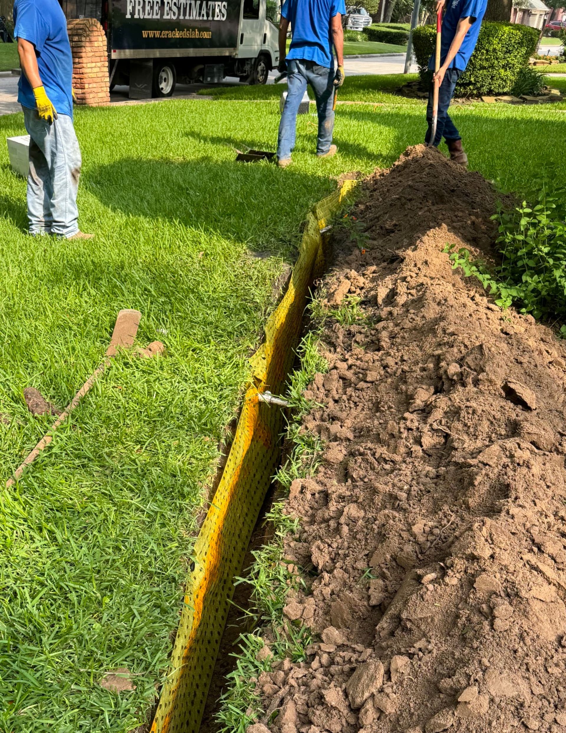 Yellow BioBarrier® in the trench with three workers in the background at left