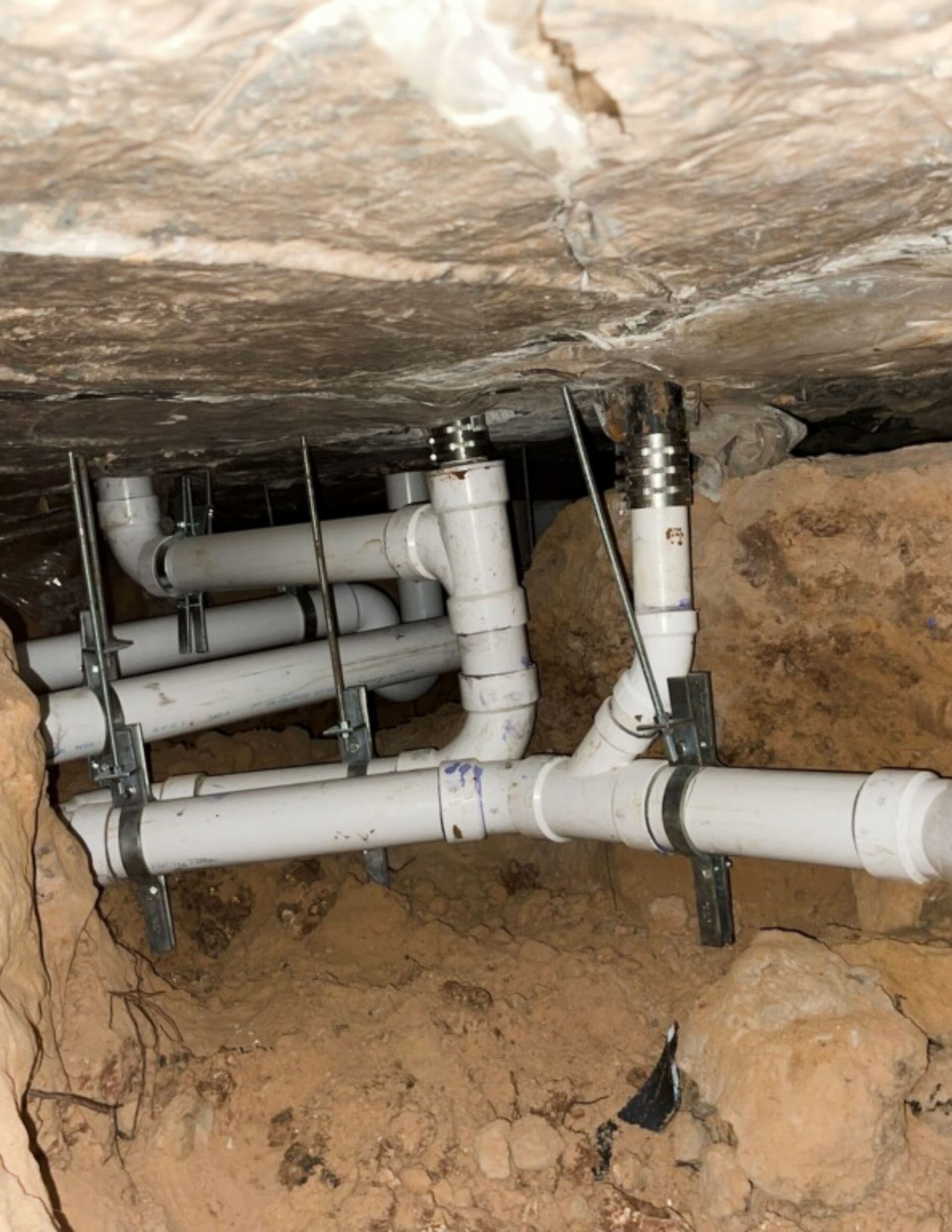 New plumbing anchored beneath the concrete slab