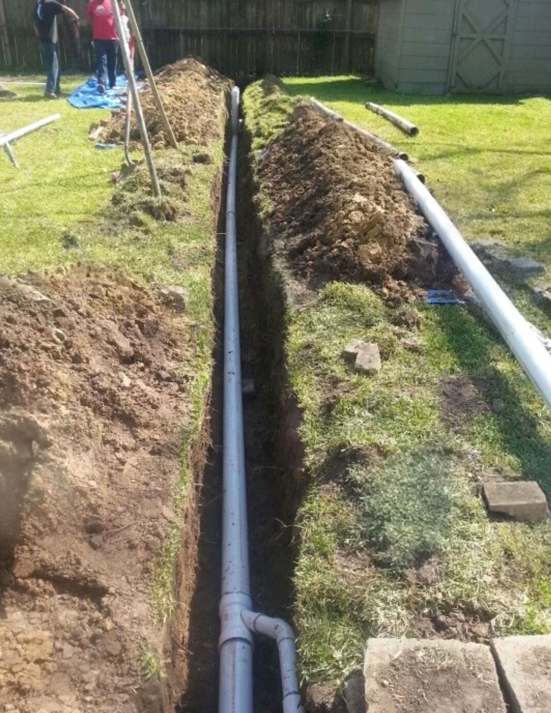 White yard line pipe installed in an exterior trench