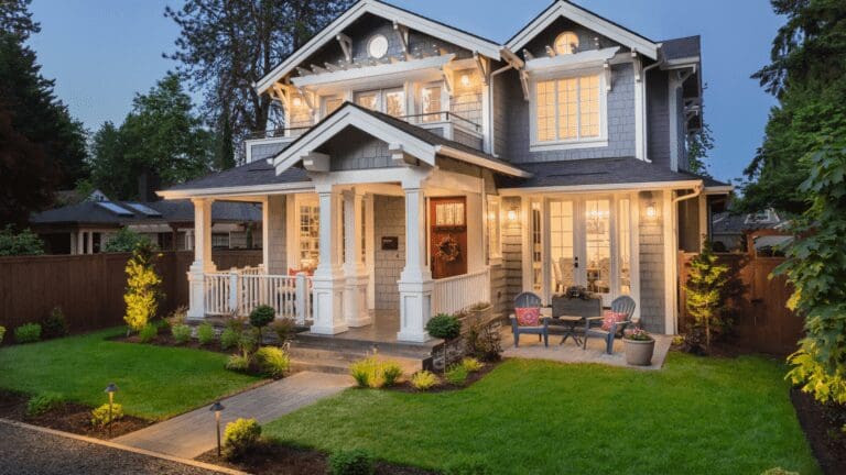 a house with two people sitting on the front porch