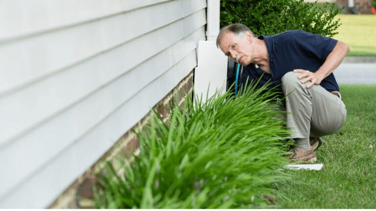 a man leaning against a house with his hand on the ground