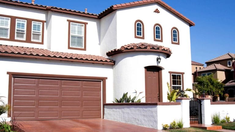 a white house with brown shutters and a gate