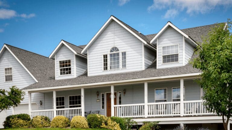 a house with white siding and windows on a sunny day