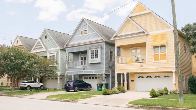 a row of houses with cars parked in front