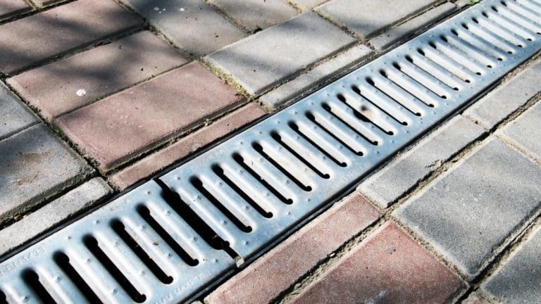 a metal grate sitting on top of a sidewalk